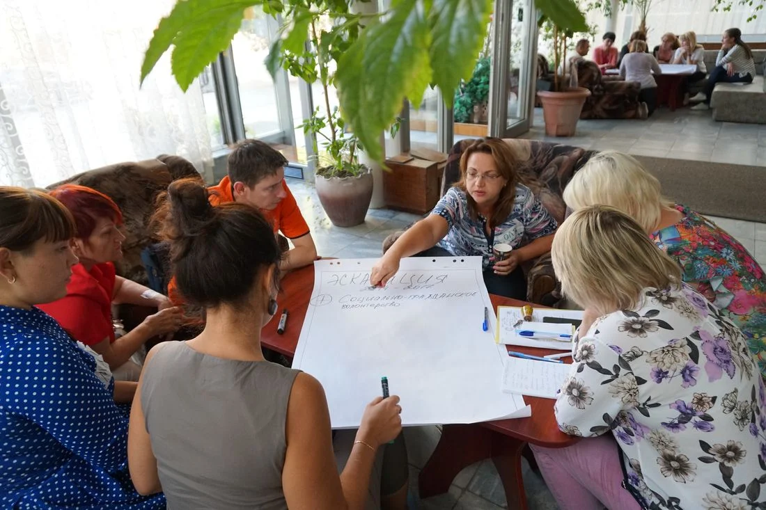 Группа участников тренинга PeaceLab анализирует документы за столом